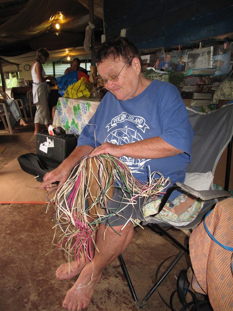 Local Pitcairner, Nola Warren, weaving baskets to be sold to tourists