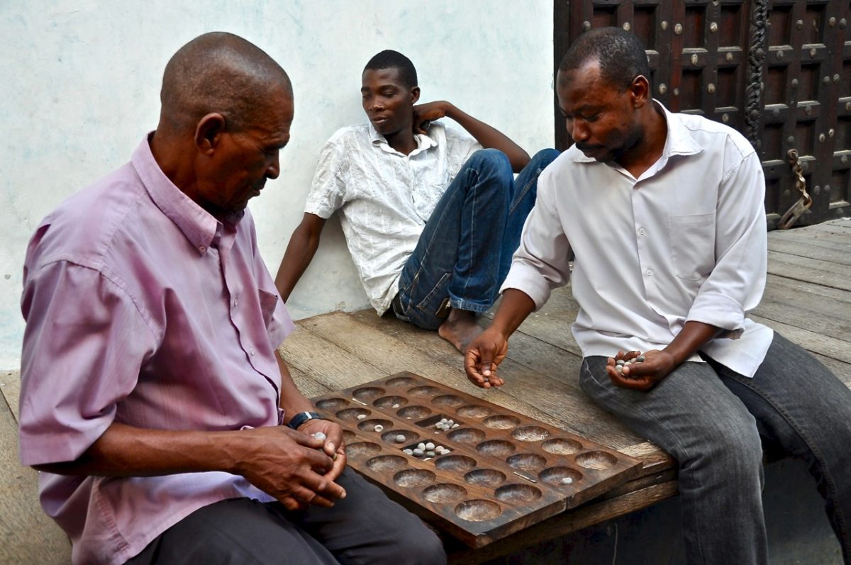 Bao players in Stone Town, Zanzibar, where Bao societies like the Chama cha Bao even hold official tournaments!