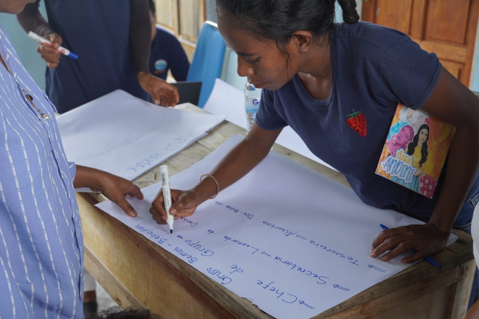 A member of a savings and loan group from Ilimanu drafting the group’s constitution